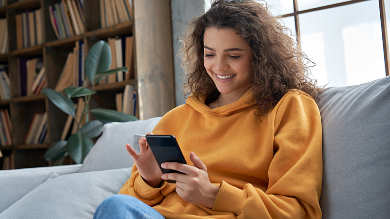 Happy millennial looking at her cell phone